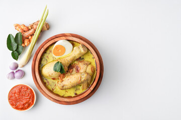 Lontong opor ayam is an Indonesian traditional dish usually served during eid Mubarak, Eid al Fitr holiday celebration with Ketupat Lebaran or rice cake dumpling and sambal chili sauce.