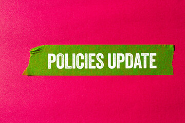 Policies update message written on ripped torn green paper tape on pink background. Conceptual policies update symbol. Copy space.