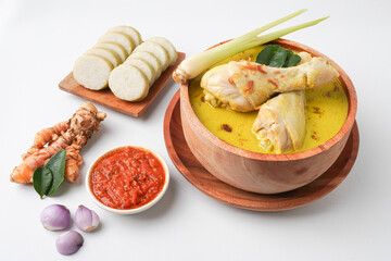 Lontong opor ayam is an Indonesian traditional dish usually served during eid Mubarak, Eid al Fitr holiday celebration with Ketupat Lebaran or rice cake dumpling and sambal chili sauce.