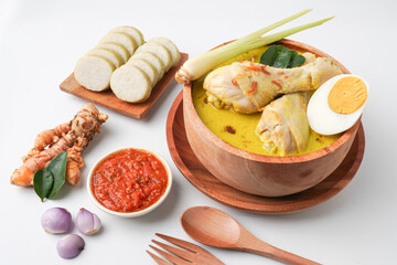 Lontong opor ayam is an Indonesian traditional dish usually served during eid Mubarak, Eid al Fitr holiday celebration with Ketupat Lebaran or rice cake dumpling and sambal chili sauce.