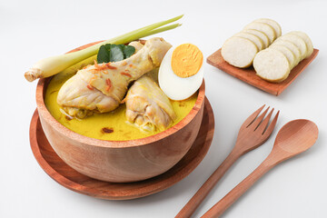 Lontong opor ayam is an Indonesian traditional dish usually served during eid Mubarak, Eid al Fitr holiday celebration with Ketupat Lebaran or rice cake dumpling and sambal chili sauce.