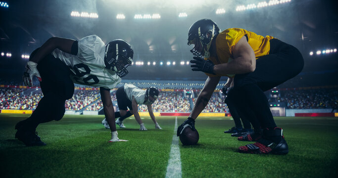 Strong Masculine Defensive Players Holding Off Competitors After Making a Pass. Intense Action From an American Football Match During a Night Championship Game with Athleticism Sportsmen