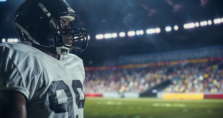 Portrait of a Focused American Football Player Standing Outdoors in a Stadium Under Heavy Rain....