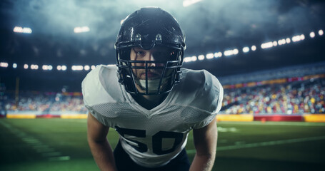 Focused Caucasian Male American Football Player in a Helmet and Protective Uniform. Close Up Portrait of a Footballer on a Stadium Field, Standing in a Position for a Championship Game to Begin