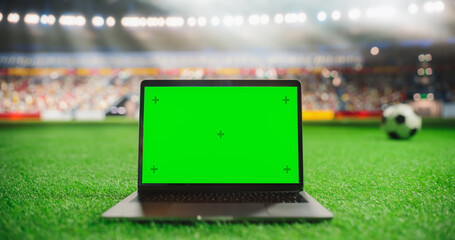 Laptop with a Green Screen Mock Up Display with a Soccer Ball Rolling in the Background on a...