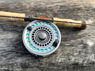 Fly fishing rod and reel resting on a dead tree