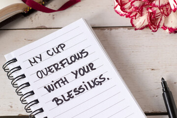 My cup overflows with Your blessings, inspirational handwritten quote and holy bible on wooden...