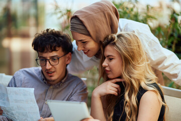 Fototapeta premium A Diverse MultiEthnic Group Reviewing Projects During a Work Break in a Caffee.
