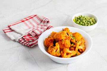 Aloo Phulkopir Dalna is a Bengali potato and cauliflower curry, cooked with spices, tomatoes, and ginger in a rich gravy.