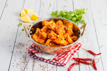 Aloo Phulkopir Dalna is a Bengali potato and cauliflower curry, cooked with spices, tomatoes, and ginger in a rich gravy.