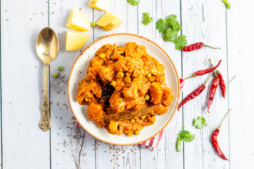 Aloo Phulkopir Dalna is a Bengali potato and cauliflower curry, cooked with spices, tomatoes, and ginger in a rich gravy.