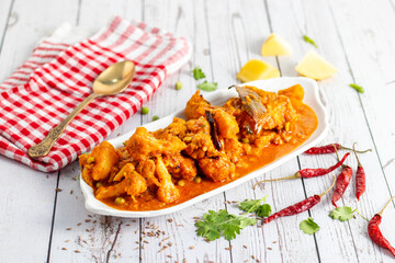 Aloo Phulkopir Dalna is a Bengali potato and cauliflower curry, cooked with spices, tomatoes, and ginger in a rich gravy.