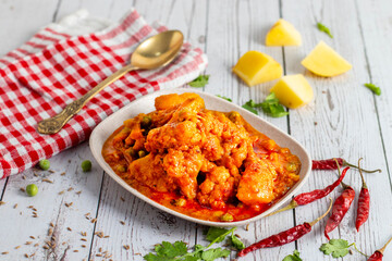 Aloo Phulkopir Dalna is a Bengali potato and cauliflower curry, cooked with spices, tomatoes, and ginger in a rich gravy.