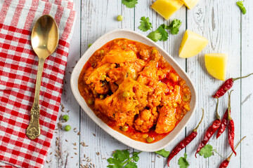 Aloo Phulkopir Dalna is a Bengali potato and cauliflower curry, cooked with spices, tomatoes, and ginger in a rich gravy.