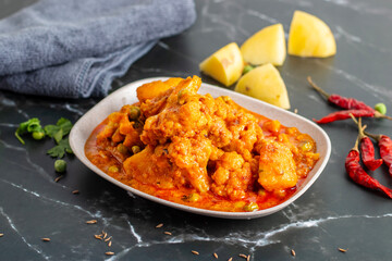 Aloo Phulkopir Dalna is a Bengali potato and cauliflower curry, cooked with spices, tomatoes, and ginger in a rich gravy.