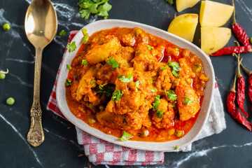 Aloo Phulkopir Dalna is a Bengali potato and cauliflower curry, cooked with spices, tomatoes, and...