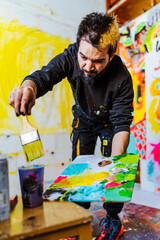 Artist Mixing Paint on a Palette in His Creative Studio. An Argentine artist prepares paint on a...