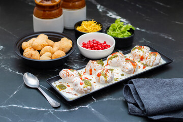Dahi Bhalla is a popular Indian snack made of deep-fried lentil dumplings soaked in creamy yogurt, topped with tangy chutneys, spices, and pomegranate.