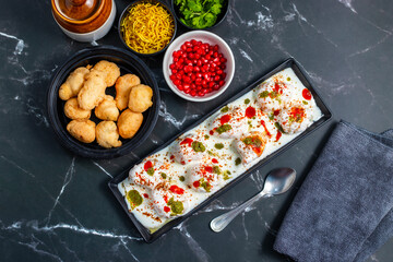 Dahi Bhalla is a popular Indian snack made of deep-fried lentil dumplings soaked in creamy yogurt, topped with tangy chutneys, spices, and pomegranate.