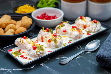 Dahi Bhalla is a popular Indian snack made of deep-fried lentil dumplings soaked in creamy yogurt, topped with tangy chutneys, spices, and pomegranate.