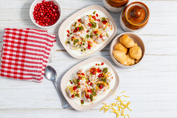 Dahi Bhalla is a popular Indian snack made of deep-fried lentil dumplings soaked in creamy yogurt, topped with tangy chutneys, spices, and pomegranate.