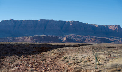 Das Bild fängt eine atemberaubende Landschaft mit einer weiten, felsigen Wüste und einer fernen...