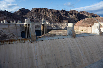 Das Bild f&auml;ngt die Pracht des Glen Canyon Dam in Arizona ein. Der aus Beton errichtete Damm steht majest&auml;tisch vor dem Hintergrund eines strahlend blauen Himmels und schroffer Berge. 