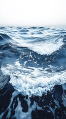 Waves crash gently on a tranquil ocean surface under a pale sky at dawn as the day begins to unfold