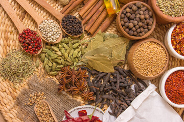 A variety of spices arranged on a straw background, showcasing rich colors and textures