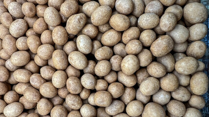 Peanuts in brown glaze are photographed close up.