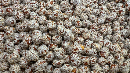 Sesame-coated peanuts lie in a random order on the display case.