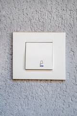 White modern doorbell button on grey wall
