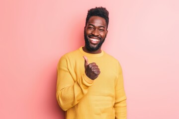 Obraz premium Portrait of a satisfied afro-american man in his 20s showing a thumb up isolated in solid pastel color wall