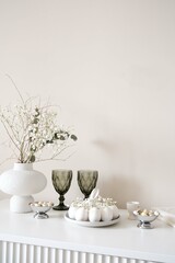 A stylish table with white eggs, colorful flowers in elegant vase, and elegant glassware ideal for spring gatherings. Easter consept.