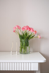 A beautiful bouquet of pink tulips beside candles enhance home decor and ambiance.