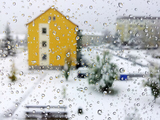 Raindrops on glass, winter view from the window onto a cozy courtyard in Germany