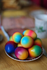 Multicolored Easter eggs lying on a plate and a wooden table