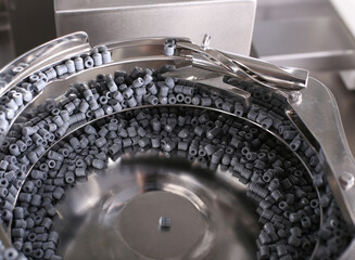 Bottling and packaging of sterile medical products. Stainless steel sorting pot with rubber stopper for syringes.