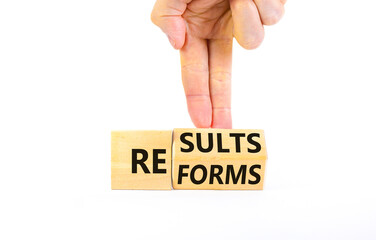 Reform and result symbol. Concept words Reforms Results on beautiful wooden block. Beautiful white table white background. Businessman hand. Business Reforms and results concept. Copy space.