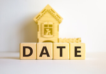 Date symbol. Concept word Date on beautiful wooden blocks. Beautiful white table white background. Wooden beautiful house. Business and date concept. Copy space.