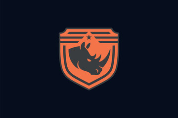 A shield-shaped emblem with a prominent rhino head in the center. The rhino is depicted in a stylized manner, with its horns and facial features clearly visible. Above the rhino, there's a small star.