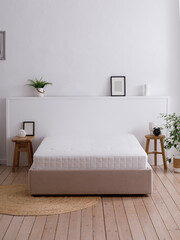 Bed with a white mattress in the interior of a modern, bright bedroom in a minimalist style with wooden floors, rug and handmade furniture. Front view photo. Suitable for mockup