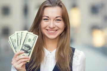 Businesswoman holding money in US dollars. Many US hundred dollar bills in female hands. Woman...