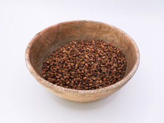 Wooden bowl with buckwheat, on a white background, side view
