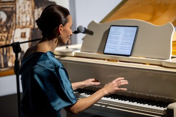 Talented pianist, beautiful woman, performer plays white grand piano