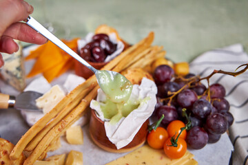 Close-up of a cheese plate with mild mold cheese, honey and olives