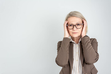 Woman overwhelmed with stress and concern, confusion and doubt, hands to head, on grey background...