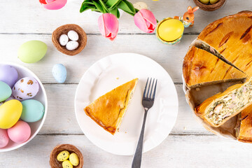 Easter Savory Pizza Pie, Traditional  Italian Easter cake pizza Rustica with ham, salami, ricotta cheese, eggs and spinach, on festive decorated table, copy space