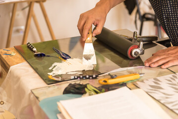 person making a wood engraving, painting, plastic artist, paint roller, paint roller