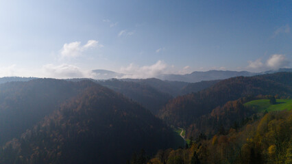 Aerial View of Rolling Forested Hills and Mountains Under Clear Blue Sky